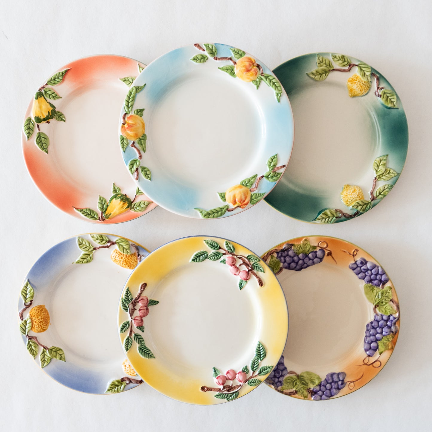 12 assiettes en barbotine fruits signées GV