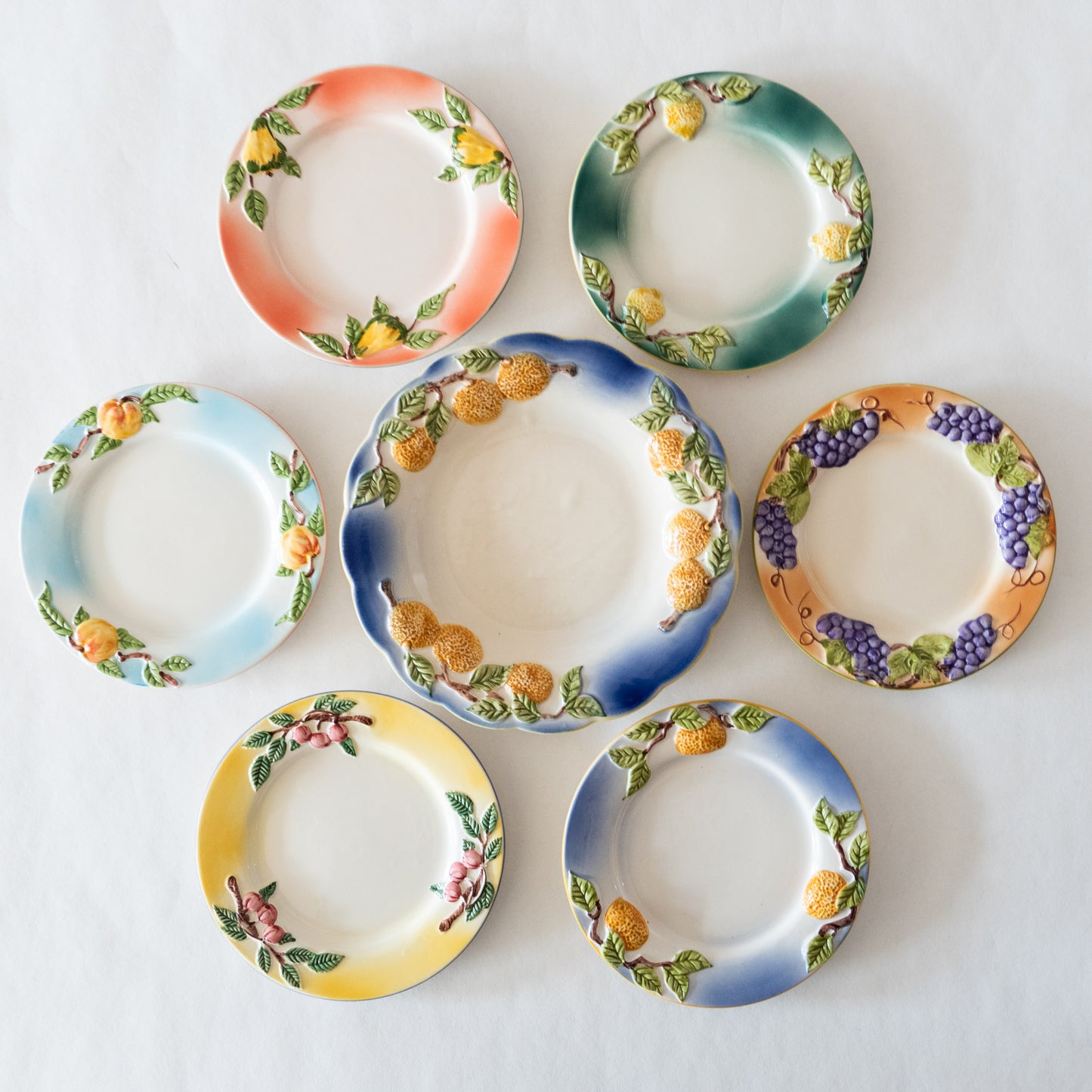 12 assiettes en barbotine fruits signées GV