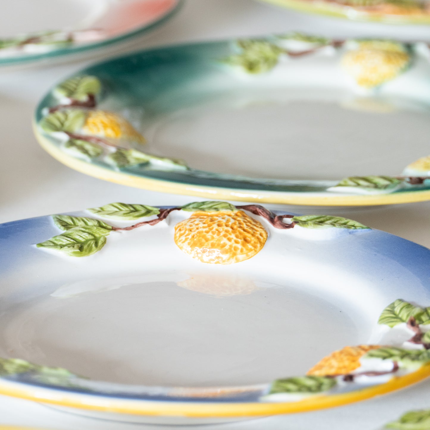 12 assiettes en barbotine fruits signées GV