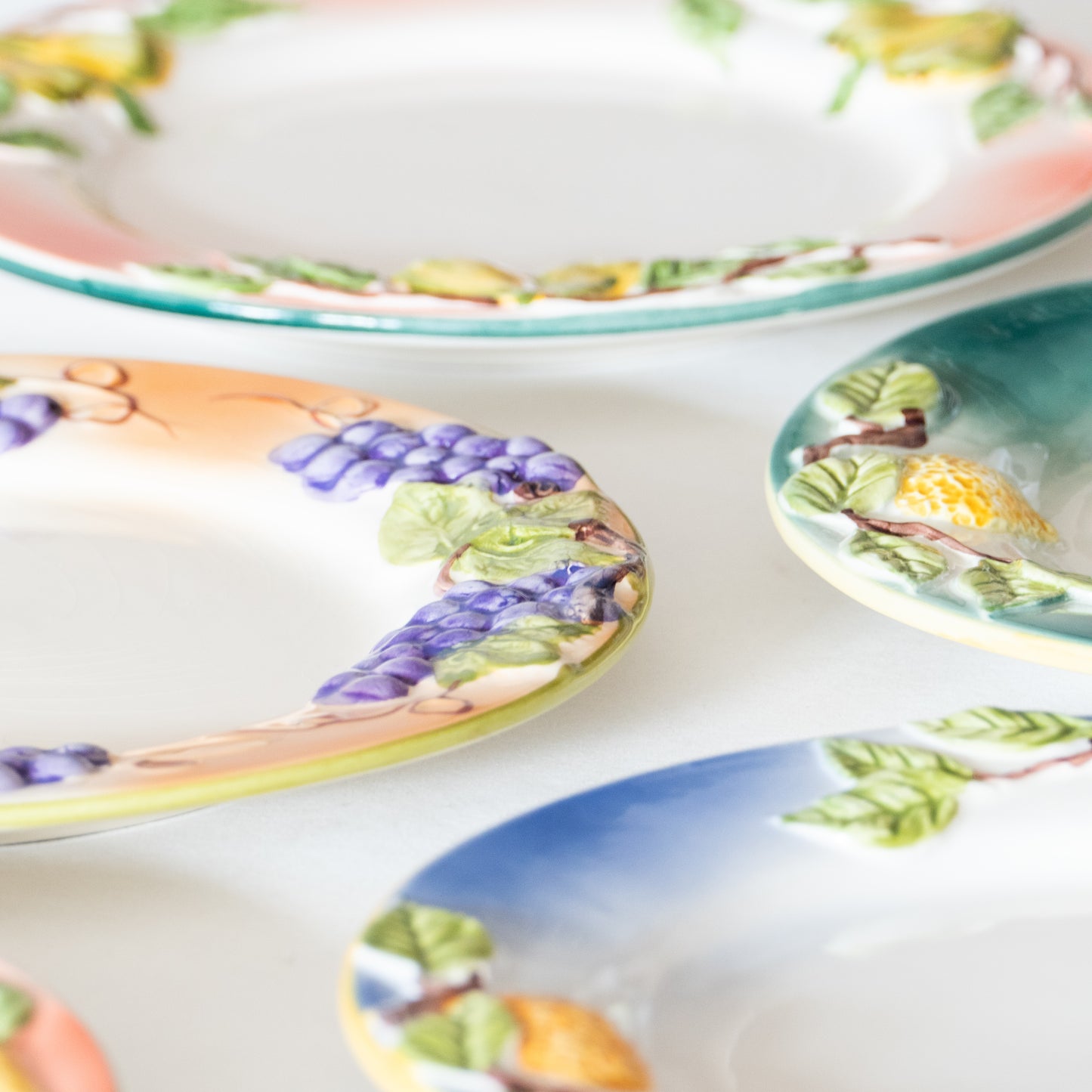 12 assiettes en barbotine fruits signées GV