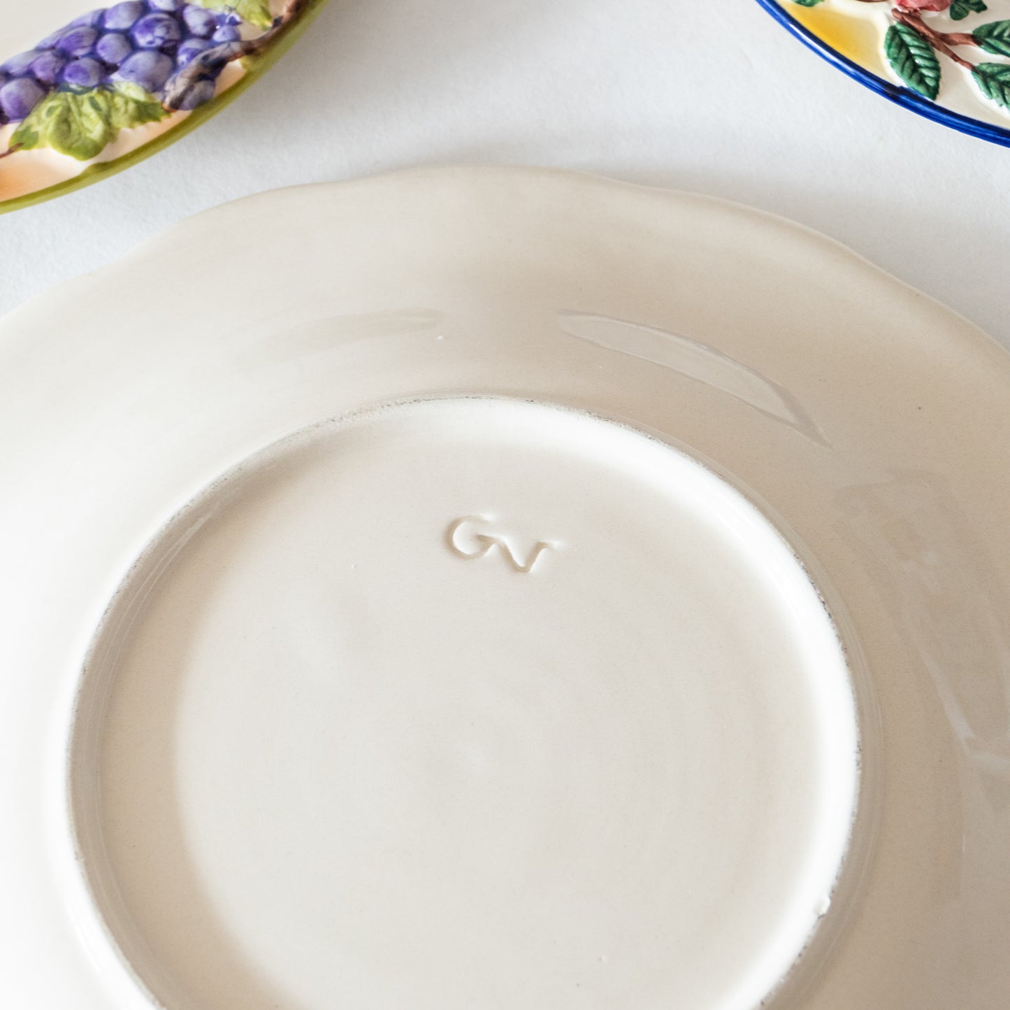 12 assiettes en barbotine fruits signées GV