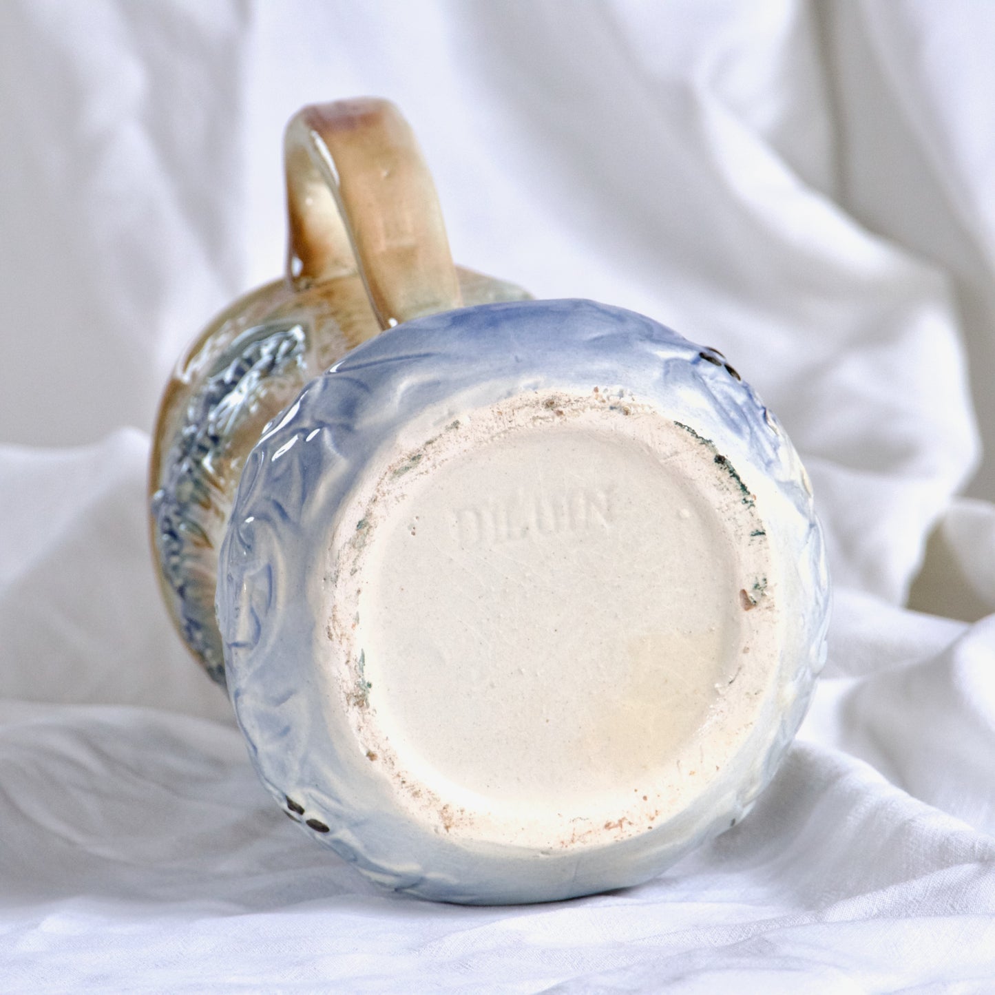 Pichet XIXe en barbotine signé Digoin