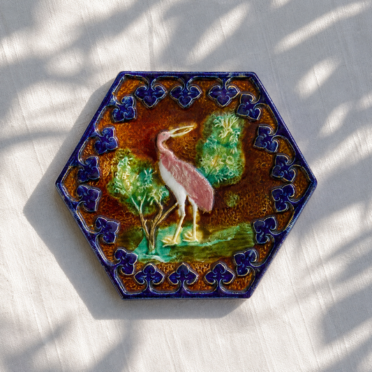 Dessous de plat XIXe en barbotine polychrome oiseau rose
